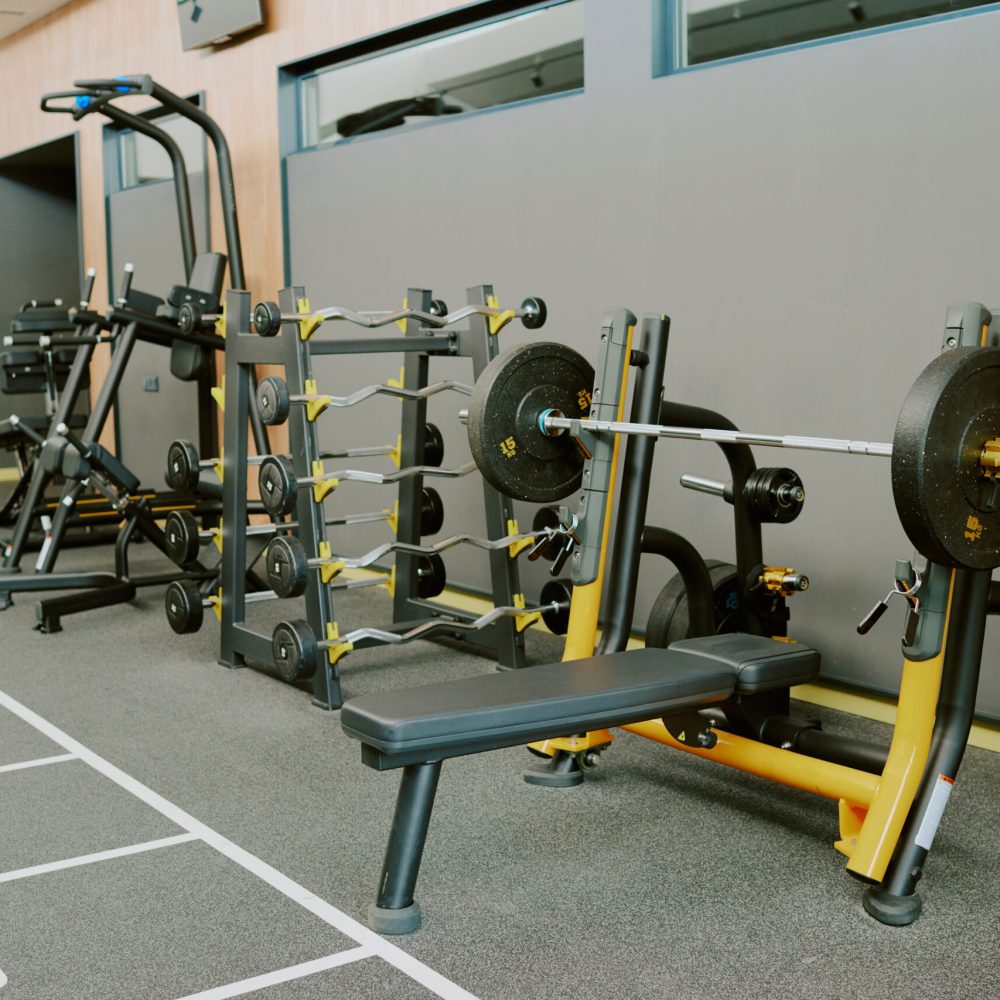 Spacious modern zone for pumping iron, zone equipped with bars plates bench